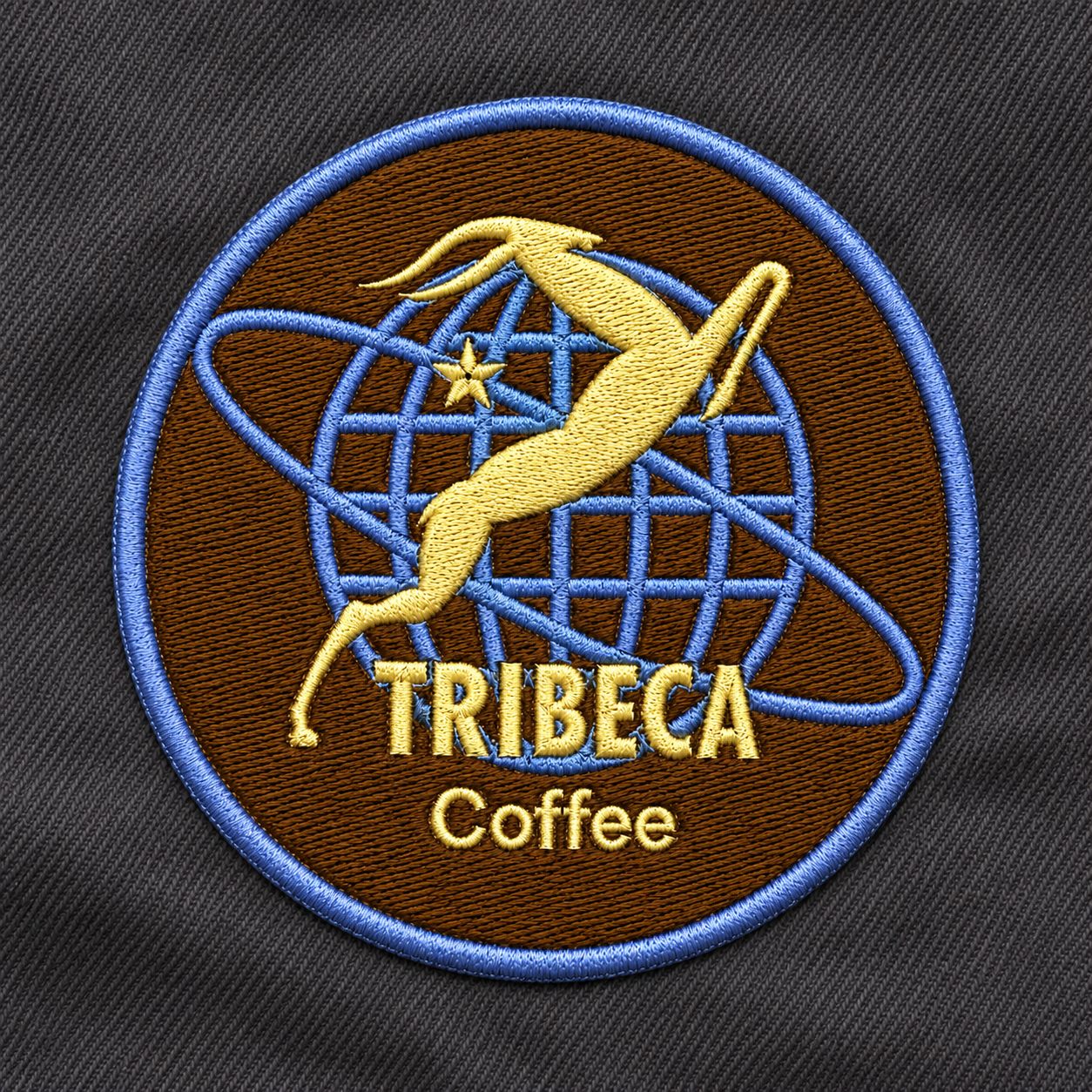 Round embroidered Tribeca Coffee badge with a gold springbok and blue globe