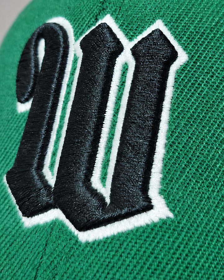 Raised black and white embroidered W on a green cap