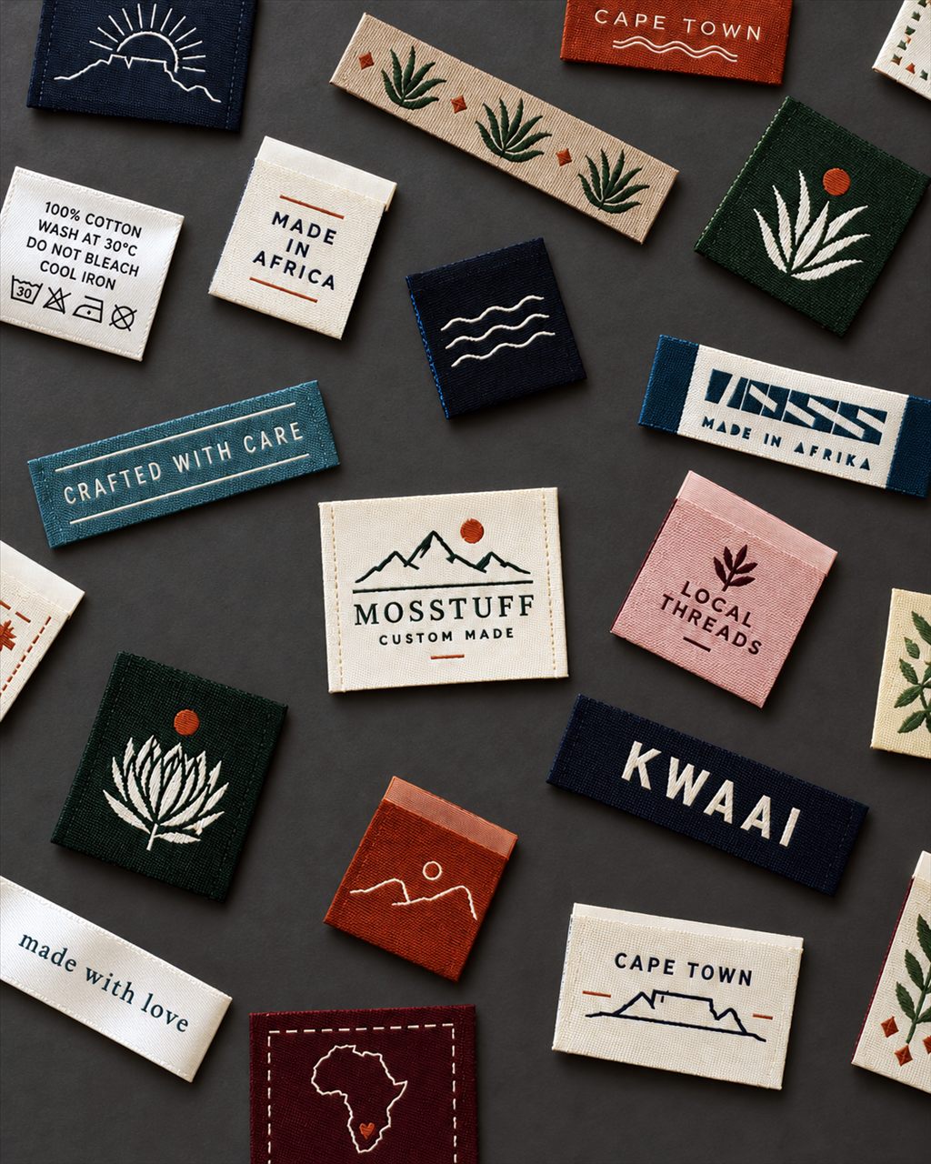 Assorted woven garment labels, including a Mosstuff custom made label and care labels