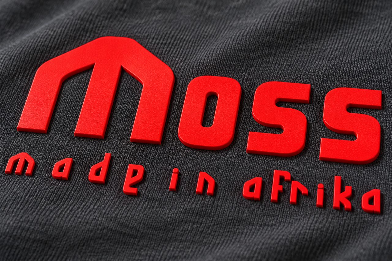 Raised red HD print reading Moss, made in Afrika, on a charcoal tee